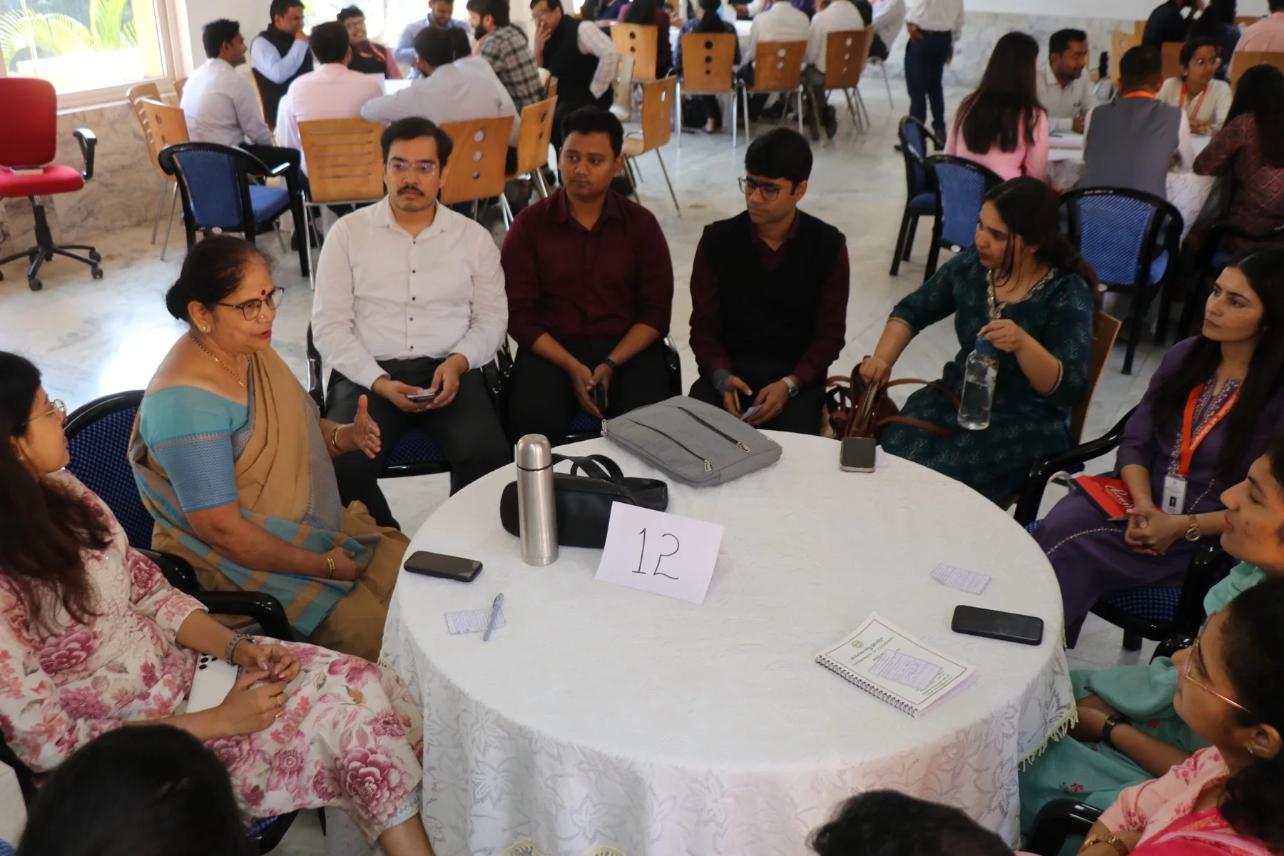 A storyteller leads a round-table conversation as participants listen.